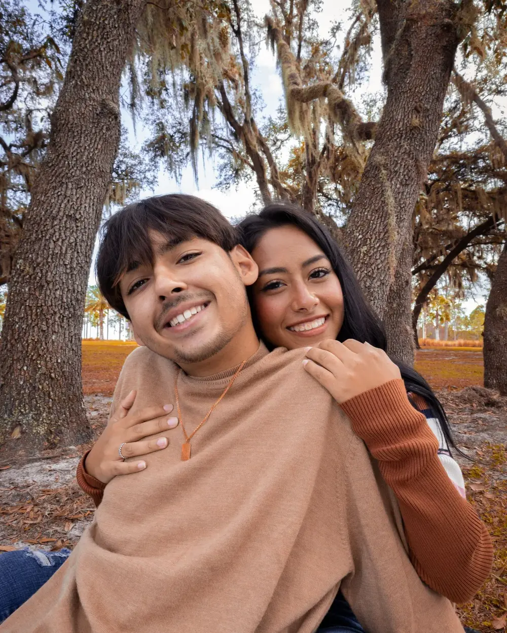 A couple laughing under trees, sharp and well framed